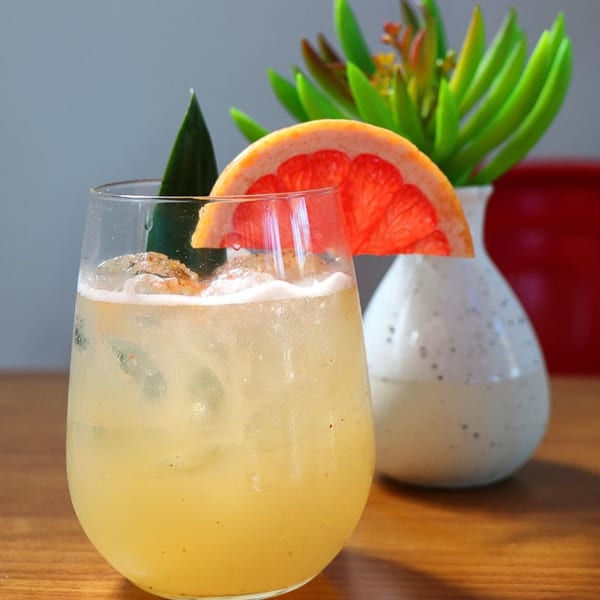 A refreshing El Taquito grapefruit cocktail with ice and a grapefruit slice garnish.